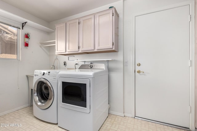 laundry room with washer and dryer and cabinets