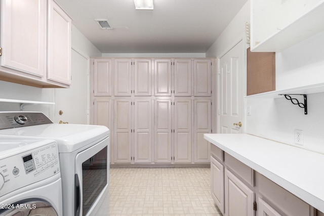 clothes washing area with cabinets and separate washer and dryer