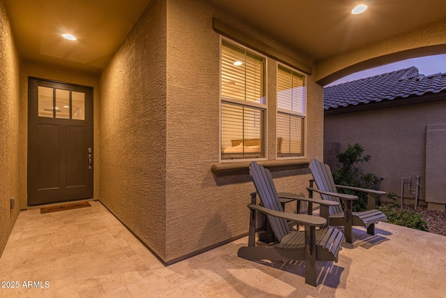 exterior space with a tiled roof and stucco siding