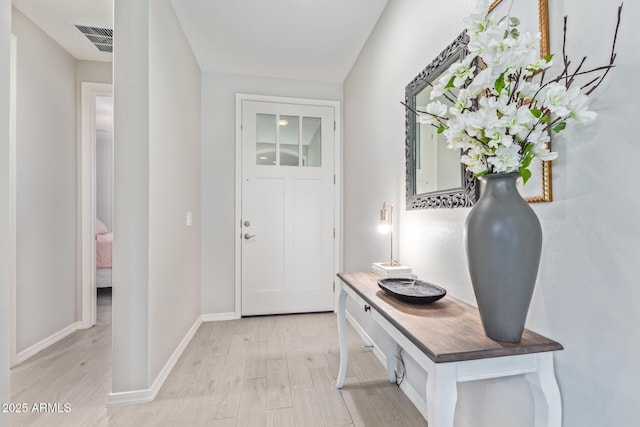 doorway featuring baseboards, visible vents, and light wood-style floors