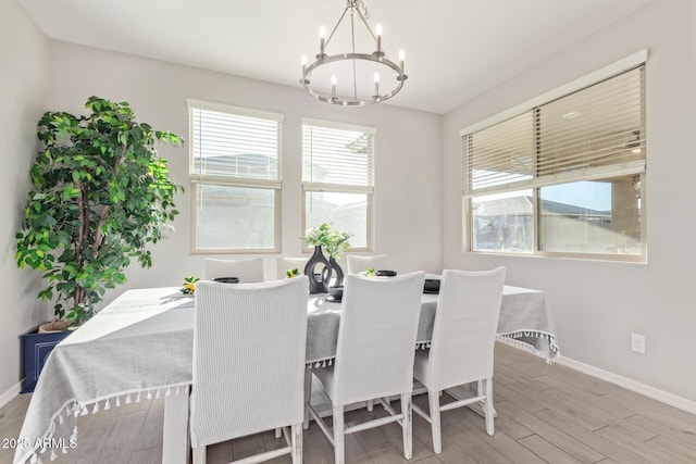 dining room with a chandelier, baseboards, and wood finished floors