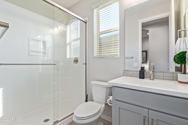 full bath featuring toilet, a shower stall, and vanity