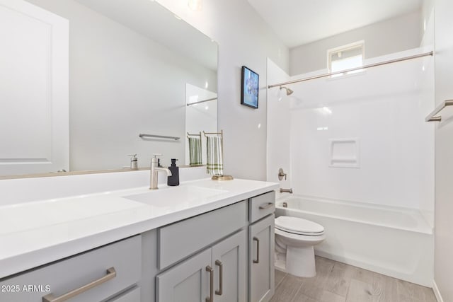 bathroom featuring toilet, washtub / shower combination, wood finished floors, and vanity