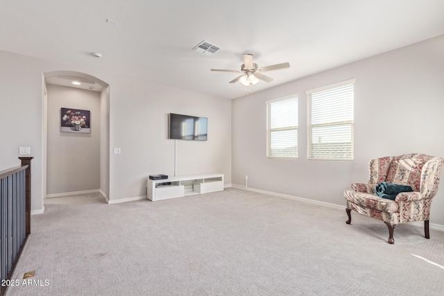 sitting room with arched walkways, baseboards, visible vents, and carpet flooring