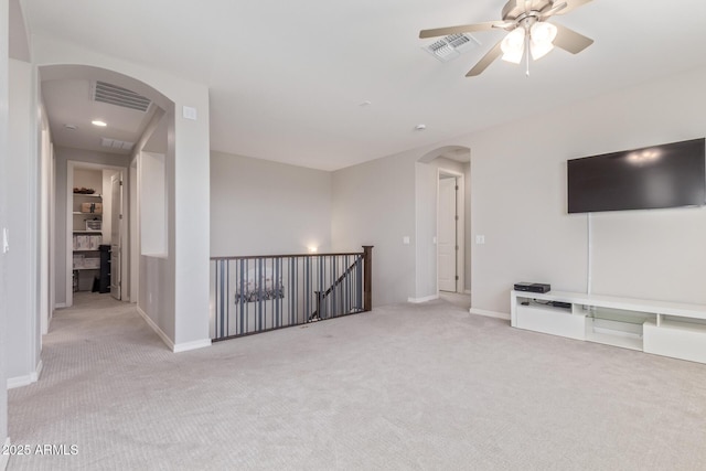 interior space with arched walkways, carpet, visible vents, and baseboards