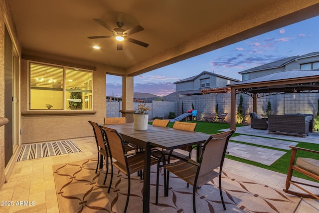 view of patio featuring ceiling fan, fence, outdoor dining area, a gazebo, and outdoor lounge area