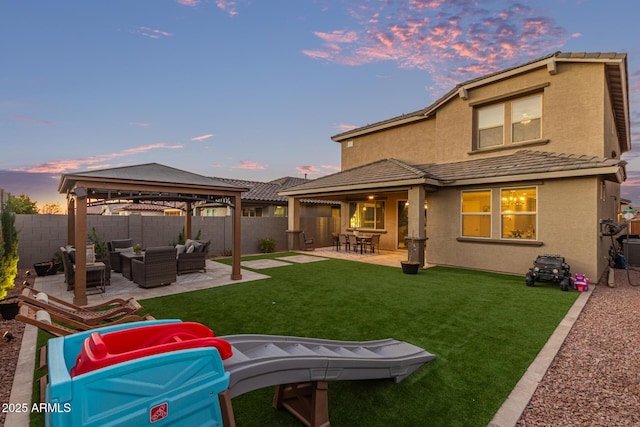 rear view of property featuring a patio, a fenced backyard, an outdoor hangout area, a gazebo, and stucco siding