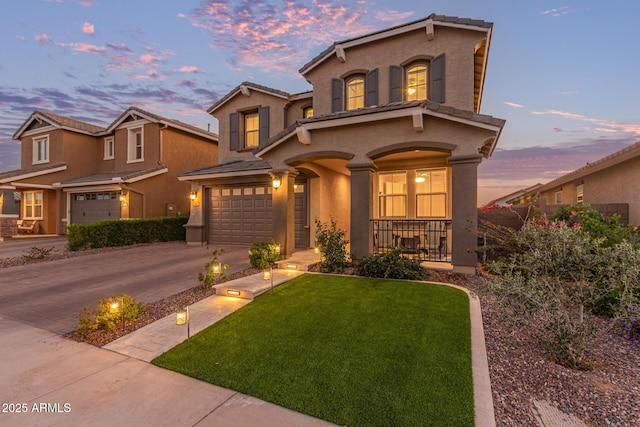 mediterranean / spanish house featuring concrete driveway, a porch, an attached garage, a front lawn, and stucco siding