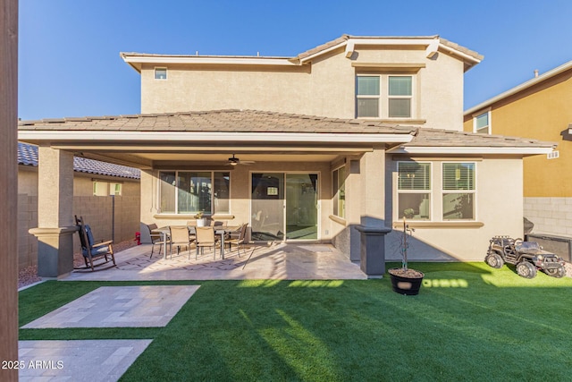 rear view of house with a patio area, fence, a lawn, and stucco siding