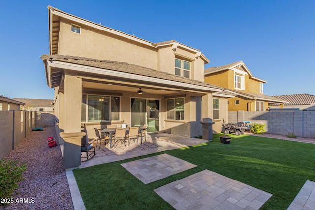 back of house featuring a patio area, a fenced backyard, a lawn, and stucco siding