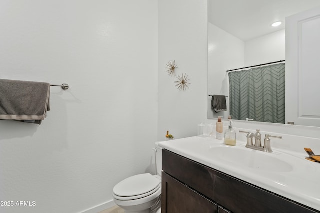 bathroom featuring vanity, curtained shower, and toilet