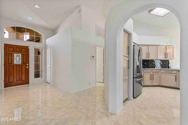 foyer entrance with recessed lighting, visible vents, arched walkways, and high vaulted ceiling