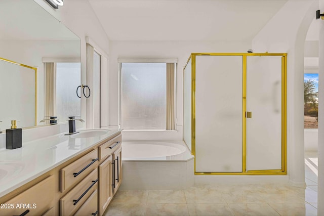 bathroom with a sink, a garden tub, double vanity, and tile patterned flooring