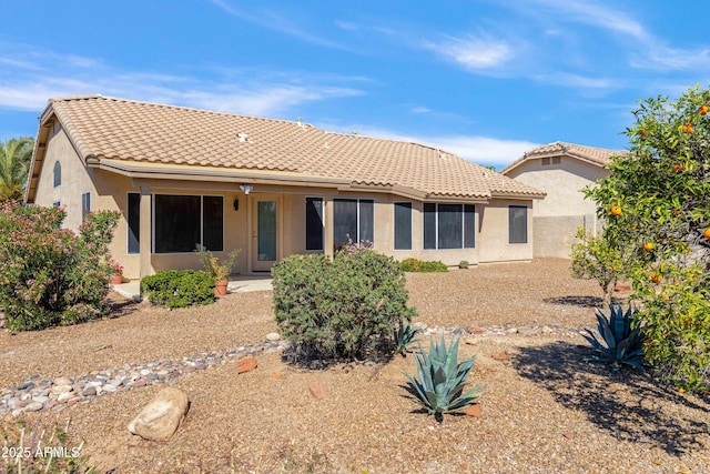 back of property featuring stucco siding and a tile roof