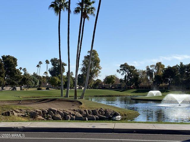 view of community with a lawn and a water view