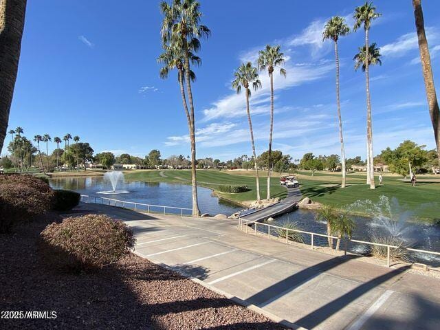 view of home's community featuring view of golf course and a water view