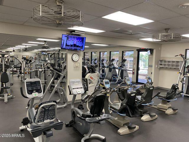 exercise room featuring baseboards and a paneled ceiling