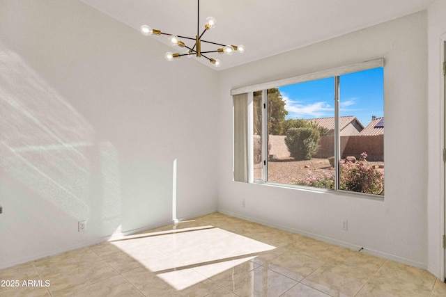 empty room featuring tile patterned flooring, a notable chandelier, and baseboards