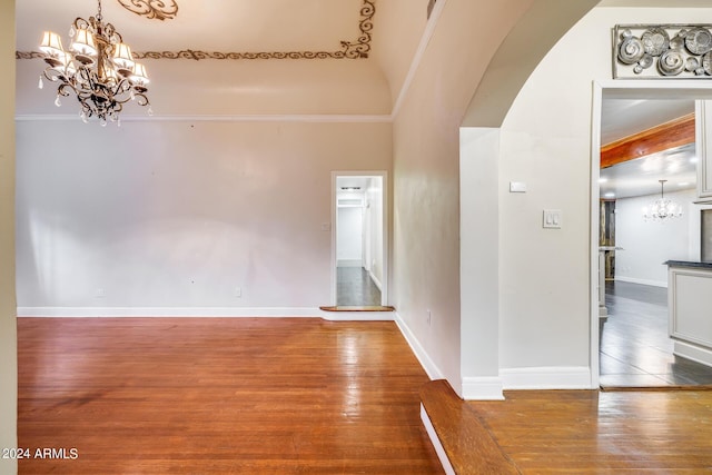 interior space featuring wood-type flooring, lofted ceiling, and crown molding