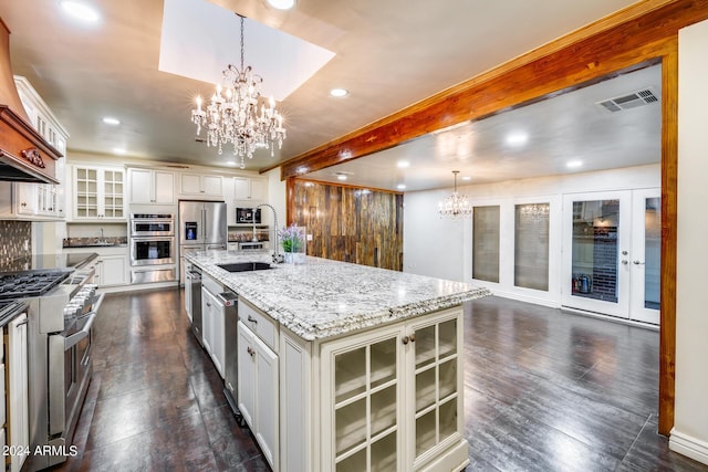 kitchen with pendant lighting, sink, an island with sink, appliances with stainless steel finishes, and white cabinetry