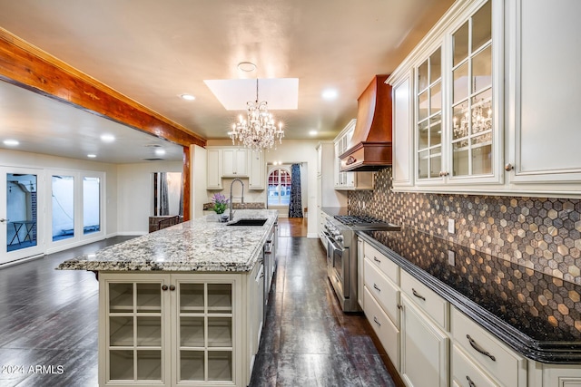 kitchen featuring custom exhaust hood, a kitchen island with sink, dark wood-type flooring, white cabinets, and high end stove