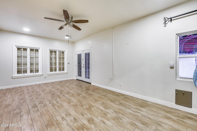 empty room with french doors, light hardwood / wood-style flooring, and ceiling fan