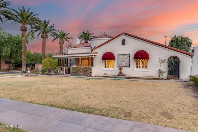 mediterranean / spanish-style house with a lawn