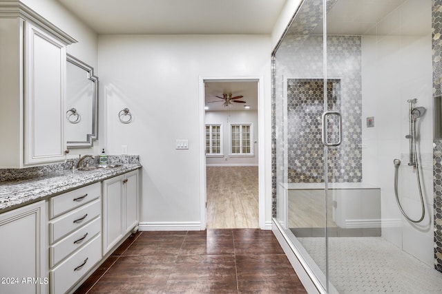 bathroom with an enclosed shower, vanity, hardwood / wood-style flooring, and ceiling fan