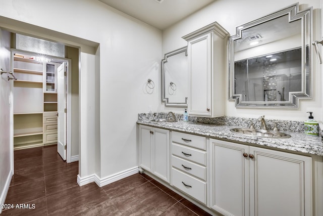 bathroom featuring a shower with door and vanity