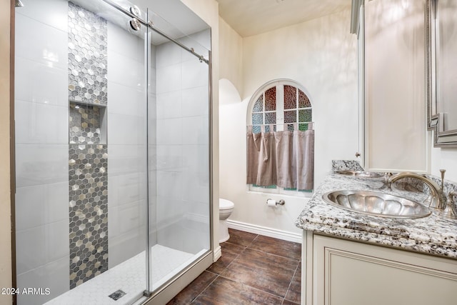 bathroom with an enclosed shower, vanity, and toilet