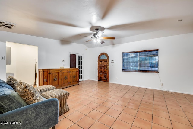 living room featuring ceiling fan, lofted ceiling, and light tile patterned flooring