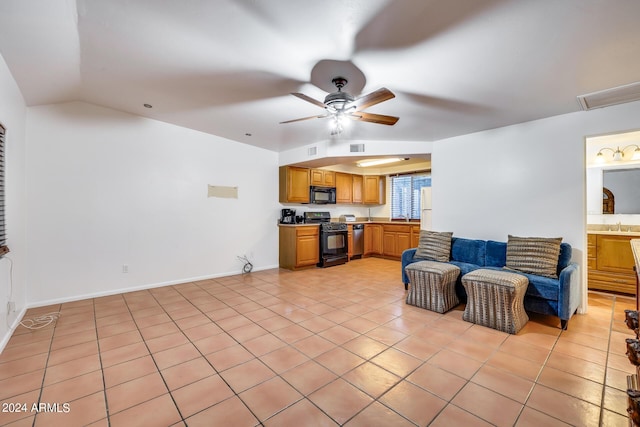 living room featuring ceiling fan, sink, light tile patterned flooring, and lofted ceiling