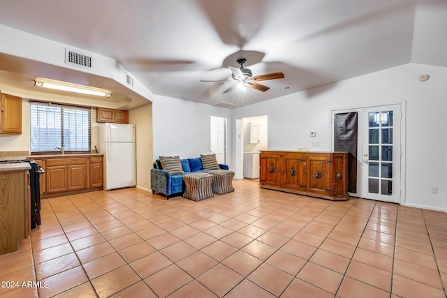 tiled living room with ceiling fan, french doors, and vaulted ceiling