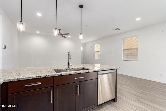 kitchen with hanging light fixtures, dark brown cabinets, stainless steel dishwasher, a sink, and recessed lighting