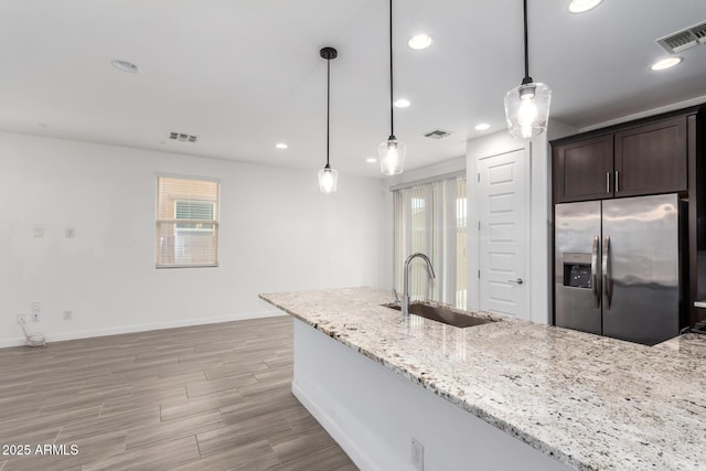 kitchen featuring dark brown cabinets, a sink, visible vents, and stainless steel fridge with ice dispenser