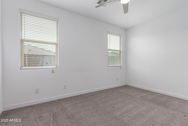 spare room with carpet, visible vents, baseboards, and ceiling fan