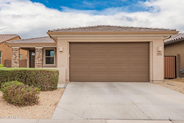 view of front of home featuring concrete driveway, an attached garage, and stucco siding