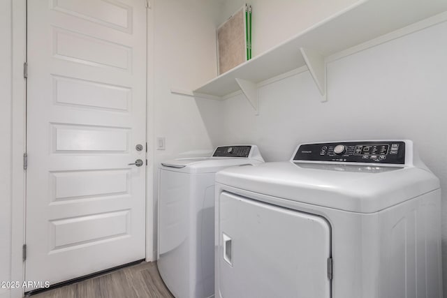 laundry area featuring light wood-type flooring, laundry area, and separate washer and dryer