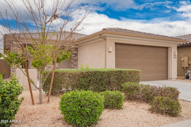 view of front of property with concrete driveway, an attached garage, and stucco siding