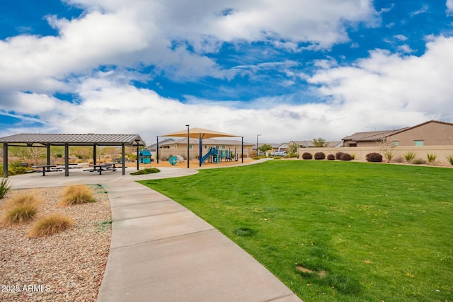 view of community with a gazebo, fence, playground community, and a yard