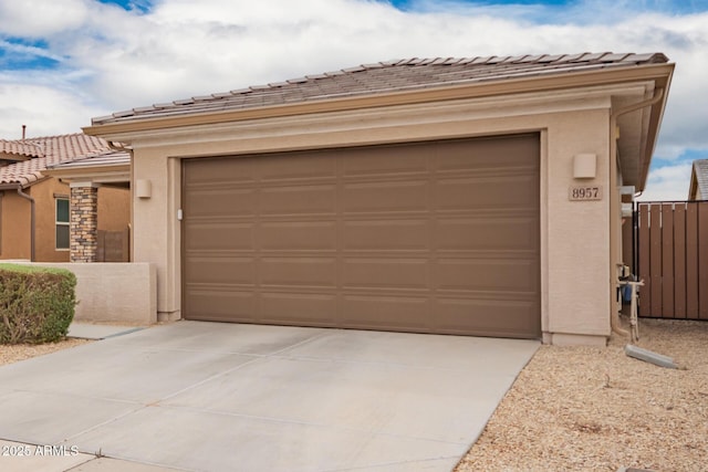 garage with driveway and fence