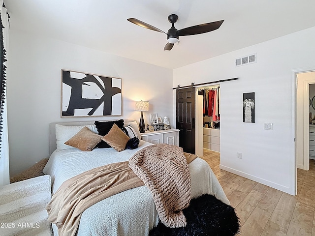 19777 N 76th St N Unit 2243, Scottsdale, AZ 85255 - bedroom featuring a barn door, light wood-style flooring, ceiling fan, and baseboards