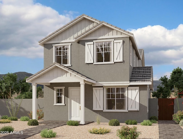 view of front of home with a mountain view, board and batten siding, stucco siding, and fence