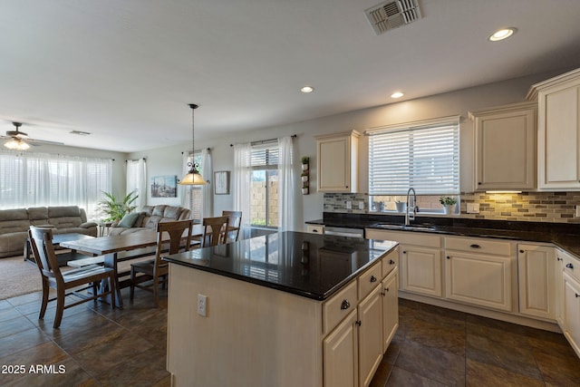 kitchen with sink, hanging light fixtures, a kitchen island, and plenty of natural light