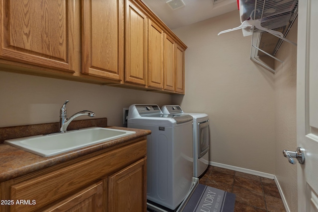 washroom featuring sink, washing machine and clothes dryer, and cabinets