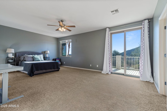 carpeted bedroom with access to exterior, ceiling fan, and a mountain view