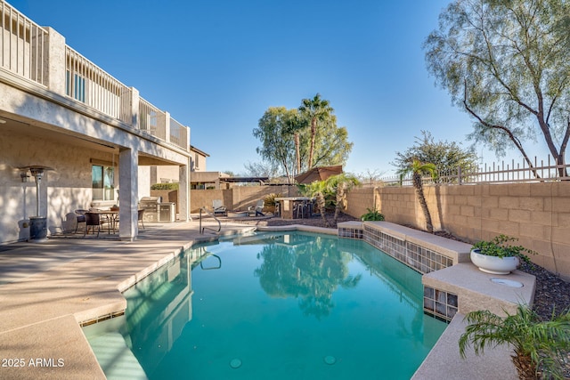 view of swimming pool featuring an outdoor kitchen and a patio area