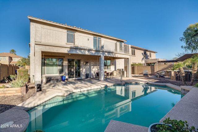 exterior space featuring a balcony, a patio, and a fenced in pool