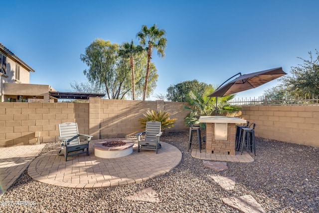 view of patio / terrace featuring an outdoor fire pit and a bar