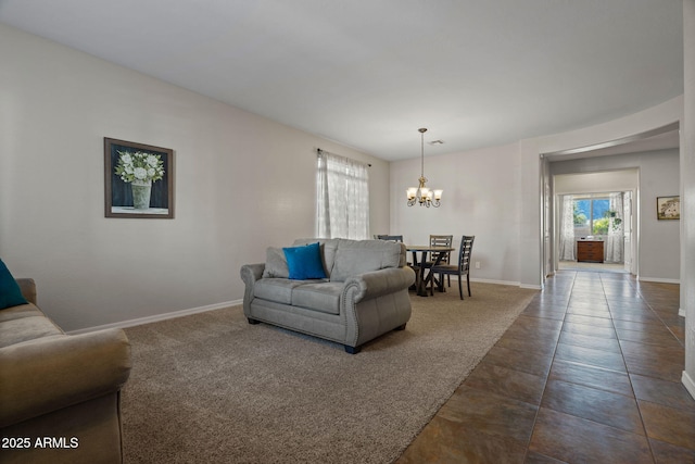 living room featuring a chandelier and dark carpet